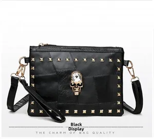 Close-up of black lychee leather bag featuring golden studs and a crystal skull motif