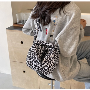 Détail du sac bandoulière léopard tendance porté sur un sweat-shirt décontracté gris
