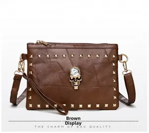 Detailed view of brown crossbody bag with gold studs and crystal skull embellishment