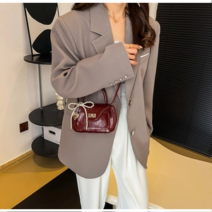 Detail of burgundy PU leather mini handbag with pearl bow and heart metal charm