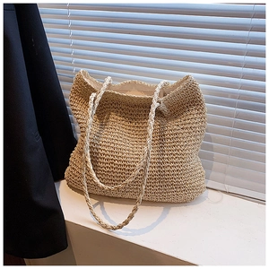 Minimalist straw woven tote bag for women in beige displayed on a stylish white table