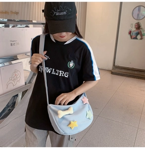 Détail du sac bandoulière en nylon bleu clair avec d'adorables étoiles en peluche