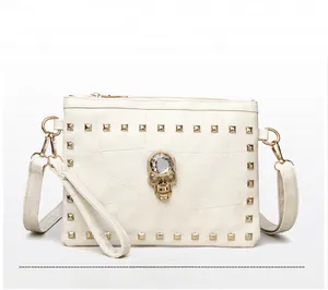 Detailed macro view of white textured leather bag with gold rivets and skull ornament