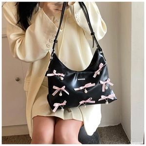 Detail of black PU Hobo bag featuring pink satin bows and white pearl pendant charms