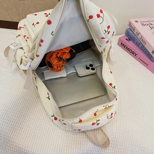 Intérieur spacieux du sac à dos en velours blanc à motifs cerises avec tablette et objets