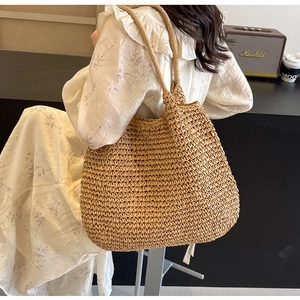Close-up of a large woven straw shoulder bag showing dense texture and eco-friendly style