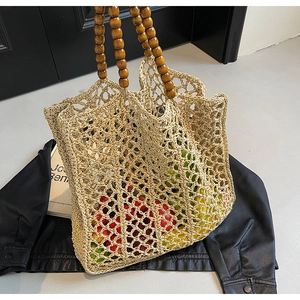 Handwoven beige mesh straw bag with dark brown wood bead handles in boho style