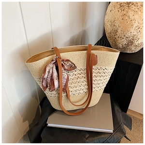 Chic woven straw tote bag with brown leather handles and printed scarf accessory