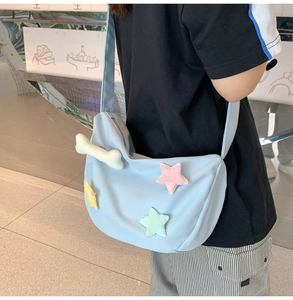 Détail d'un sac bandoulière en nylon bleu clair avec d'adorables étoiles en peluche