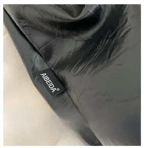 Detailed close-up of high-gloss black PU leather texture with brand woven label