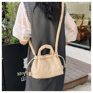 Detailed close-up of beige quilted polyester drawstring bag showing soft fabric texture