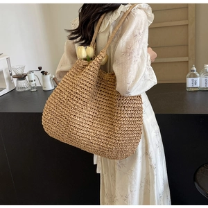 Detail of hand-woven straw tote bag showing dense texture and large capacity design