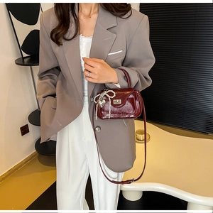Detail of vintage burgundy PU leather handbag with pearl bow and silver heart pendant charm