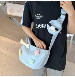 Détail du sac bandoulière en nylon bleu clair avec étoiles en peluche et décor d'os
