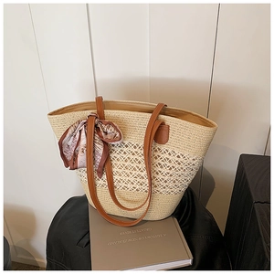Handwoven straw tote bag with diamond cutout detail and brown leather handles
