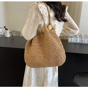Detail of hand-woven light brown tote bag featuring intricate crochet texture and long strap