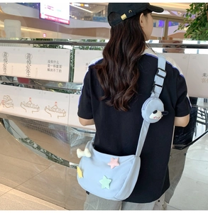 Détail du sac bandoulière en nylon bleu clair avec étoiles 3D et porte-monnaie panda