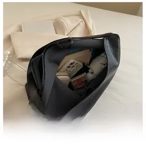 Top view showing the spacious interior of the black leather tote bag with daily essentials