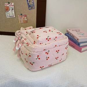 Détail d'un sac à dos rose en velours côtelé avec motif cerise et boucle latérale