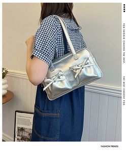 Détail du sac à bandoulière argenté métallisé avec nœuds et poches latérales chic