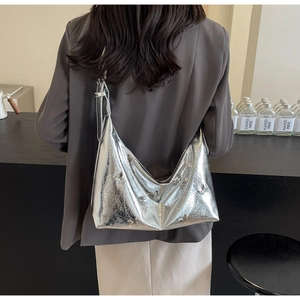 Close-up of silver hobo bag featuring reflective faux leather and 3D butterfly charms
