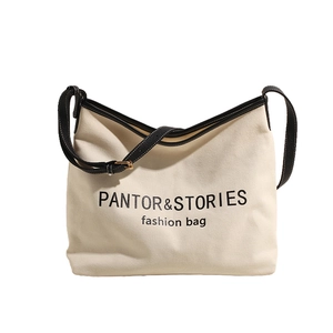 Minimalist cream canvas tote bag with black leather trim and PANTOR & STORIES artistic text