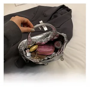 Detail showing the internal capacity of the silver pleated PU handbag with chain