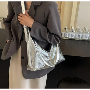 Detailed view of silver Hobo bag with metallic butterfly studs on shiny PU leather