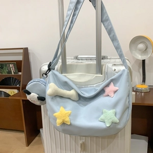 Sac bandoulière croissant bleu clair en nylon avec patchs d'étoiles sur une valise