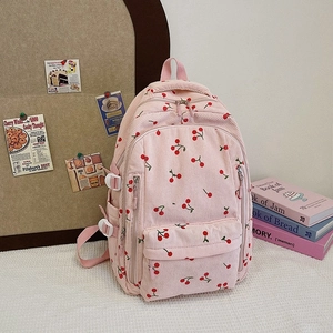 Vue détaillée du sac à dos en velours rose avec imprimés cerises et poches zippées