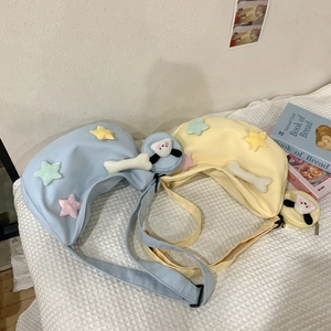 Détail de sacs bandoulière pastel macaron avec étoiles en peluche et breloques chien