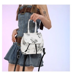 Close-up of white PU leather mini backpack featuring hand-drawn black butterfly patterns