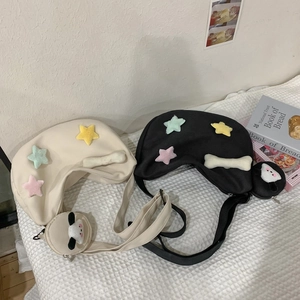 Détail de sacs bandoulière en nylon noir et crème avec de mignons pendentifs étoiles