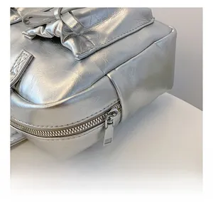 Gros plan détaillé sur la fermeture éclair argentée du sac en cuir PU froissé brillant