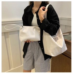 Close-up of white pleated PU leather tote bag set with matching small zipper pouch