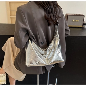 Close-up of a silver metallic half-moon bag featuring 3D butterfly ornaments and sleek PU finish