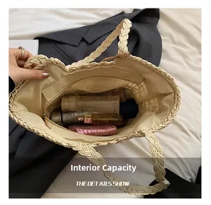 Detail view of woven straw tote bag showing spacious interior and secure zip pocket