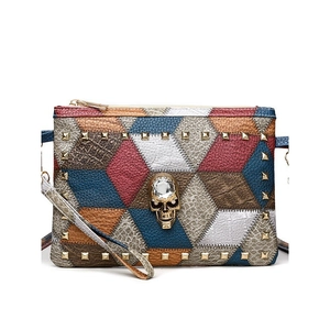 Retro patchwork crossbody bag with gold skull ornament and rivet studs detail
