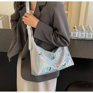 Detail showing the holographic silver PU leather texture and butterfly charms of the bag