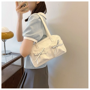 Détail du sac bandoulière blanc en PU avec nœuds argentés et poches plissées