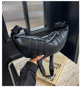 Detailed view of black PU leather croissant bag with quilted folds and knotted strap handle