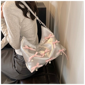 Detailed shot of silver crescent bag with pink balletcore bows and hanging pearls