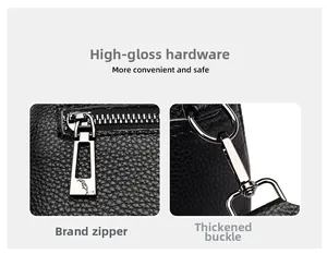 Close-up of high-gloss metal zipper and reinforced hardware on black litchi leather bag