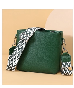 Close-up of dark green lychee grain leather bucket bag with geometric woven strap