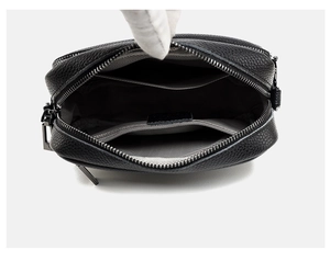 Detail view of the black lychee pattern leather handbag showing internal pockets and zippers
