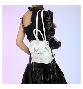 Detail of white PU mini backpack featuring green butterfly prints and metal buckle
