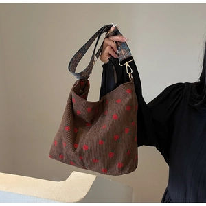 Close-up of corduroy tote bag with strawberry embroidery and vintage ethnic wide strap