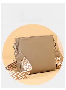 Detailed macro view of brown pebbled leather texture and geometric pattern wide shoulder strap