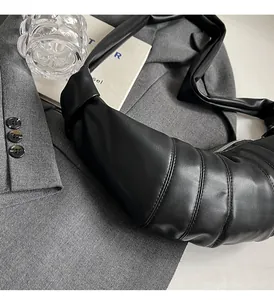Detail shot of black quilted croissant crossbody bag with soft PU leather texture