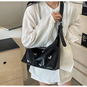 Fashionable black faux leather crossbody bag with silver butterfly details and pleated texture